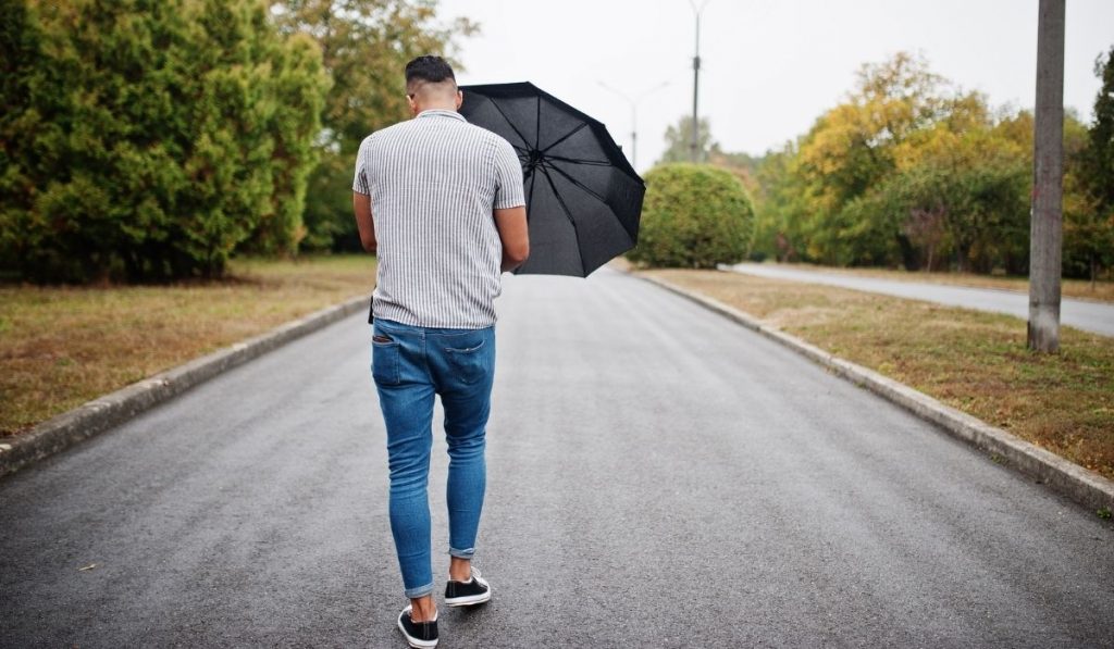 back view photo of a tall guy carrying an umbrella - ee220321