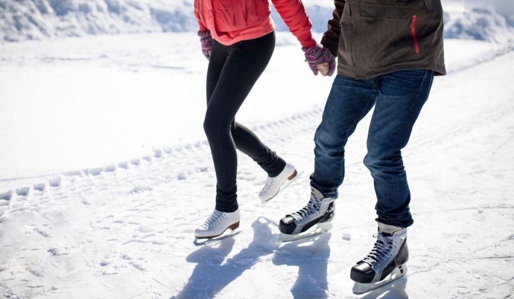 couple holding hands while ice skating - ee220321