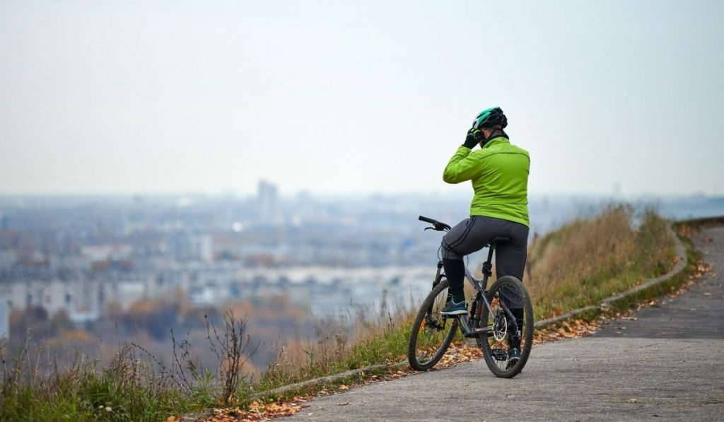 plus size cyclist on top of hill resting - ee220329