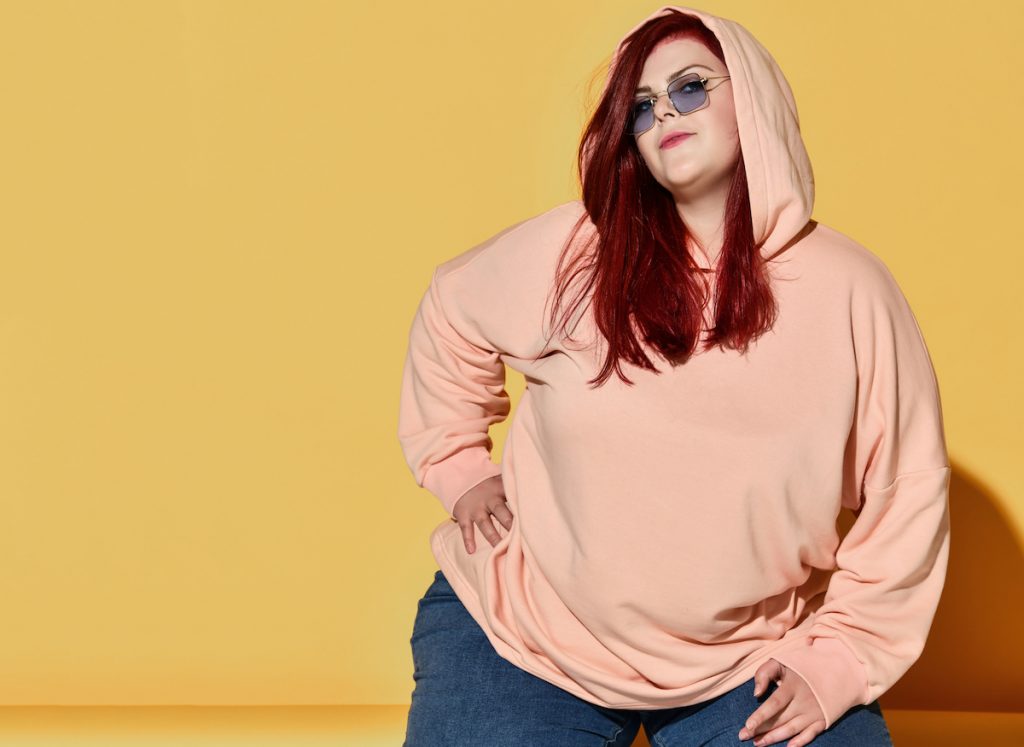 plus sized woman wearing jeans and hoodie