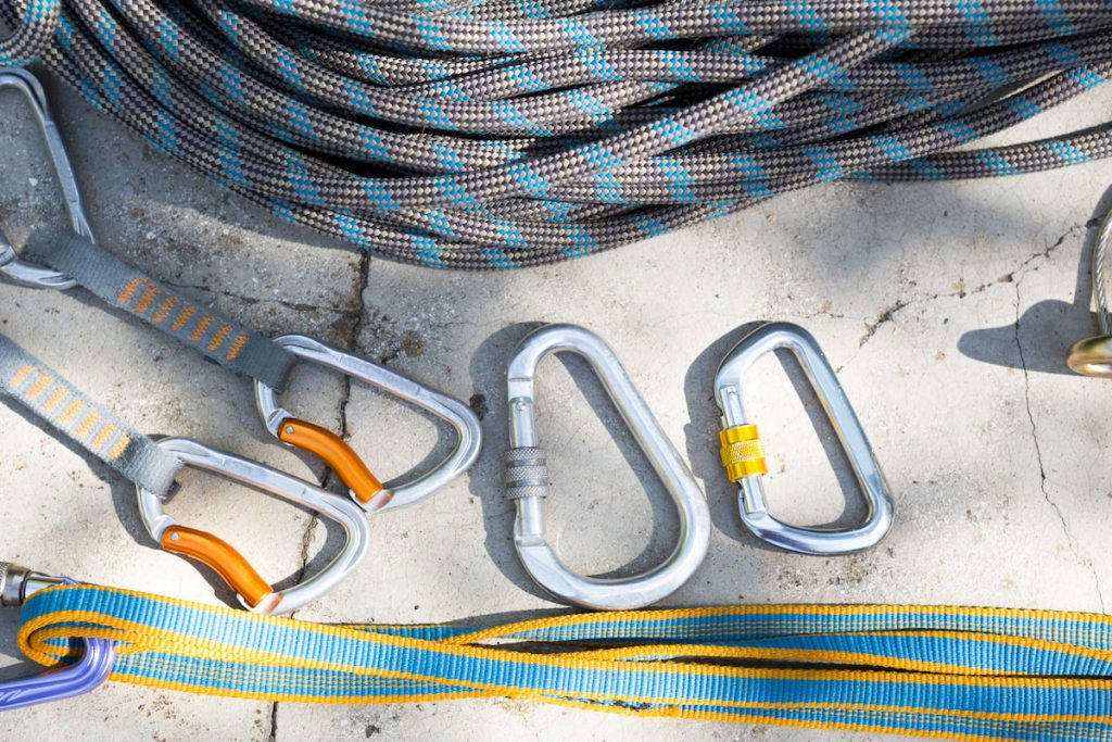 Coiled climbing rope and steel carabiner climbing equipment 