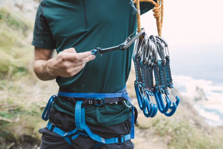 man-preparing-climbing-harness-equipment