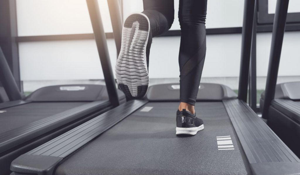 woman legs and shoes running on treadmill