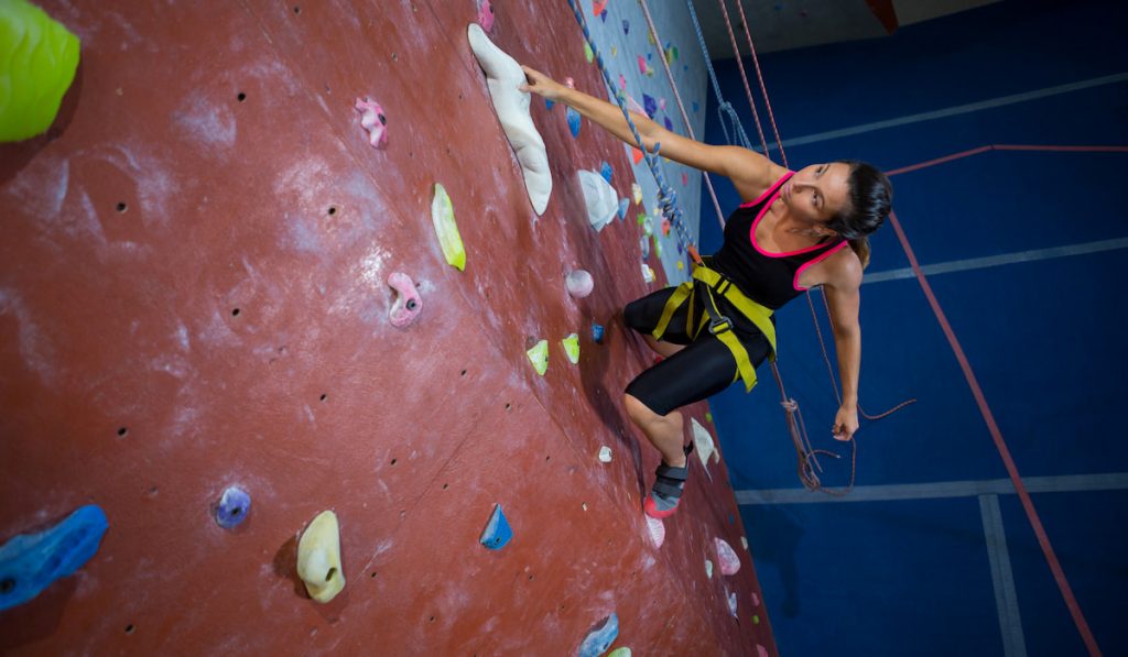 woman practicing rock climbing in studio 